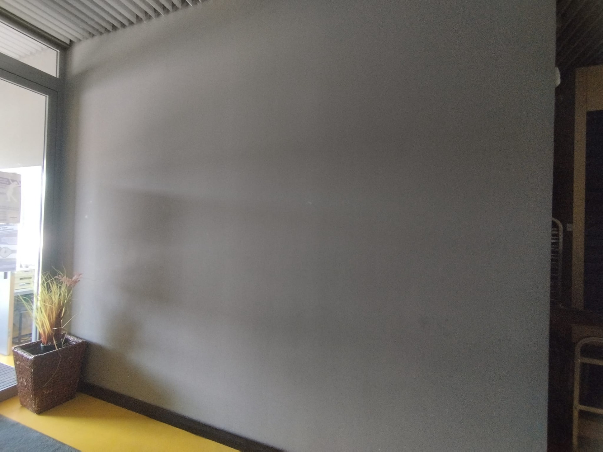 Egyszerű szürke bejárati fal dekoráció nélkül